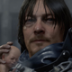 Sam from Death Stranding looks out at the viewer while cradling a baby.